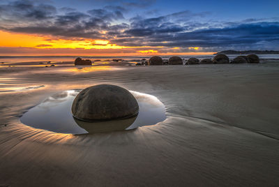 Scenic view of sea against dramatic sky during sunset