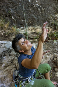 Portrait of young man with rocks on rock