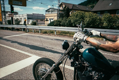 Rear view of man riding motorcycle on street