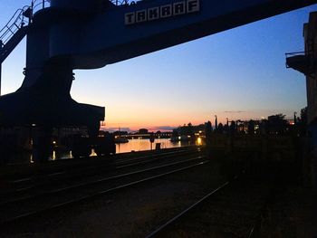 Railroad tracks in city at sunset