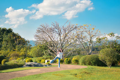 Rear view of woman walking on field against sky