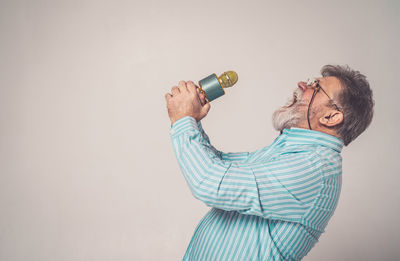 Side view of a man wearing mask against white background