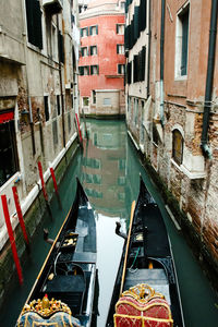 Boats moored at canal along buildings