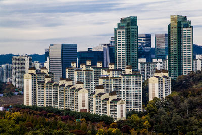 Low angle view of city against cloudy sky