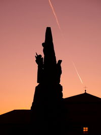 Silhouette statue against sky during sunset