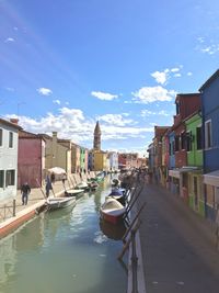 Canal amidst buildings in city against sky