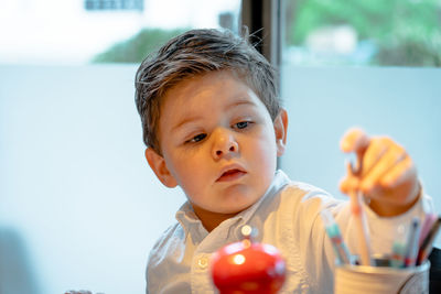 Close-up of cute boy against window