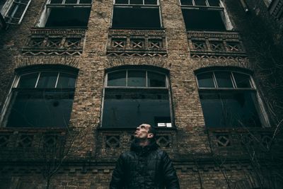 Low angle view of man standing against building