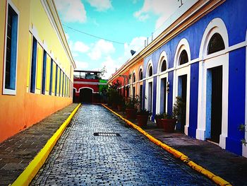 Road amidst buildings against sky