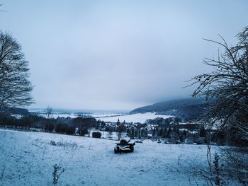 Scenic view of snow covered land against sky