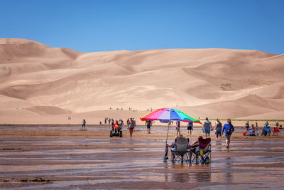 People at beach against sky