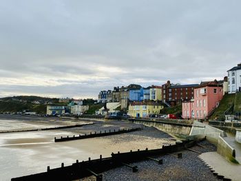 High angle view of buildings by river against sky