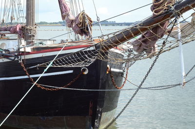 Fishing boats moored in sea against sky