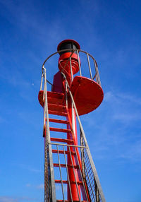 Low angle view of red tower against blue sky