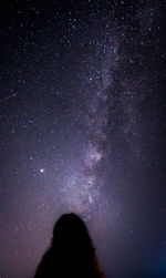 Low angle view of silhouette woman against sky at night