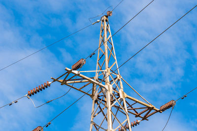 Low angle view of electricity pylon against sky