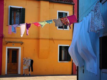 Low angle view of clotheslines by buildings