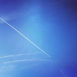 Low angle view of vapor trail against clear blue sky