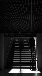 Rear view of man walking on staircase