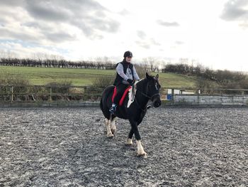 Full length of man riding horse on field against sky