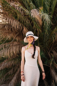 Woman wearing hat standing against plants
