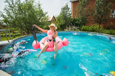 Woman jumping in swimming pool