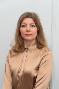 Portrait of young woman standing against wall