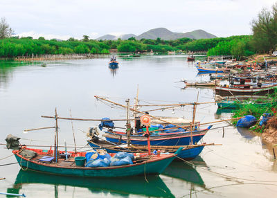 Boats moored in lake against sky