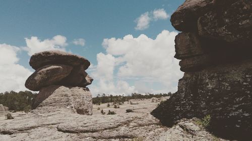 Statue on rock formation against sky