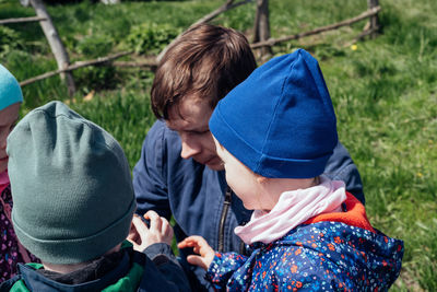 Father shows the children a lizard that he caught in the grass. active cognitive leisure 