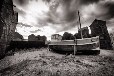 Boats moored on shore against sky