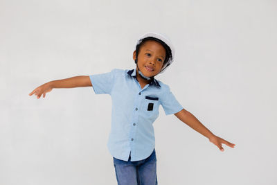 Portrait of boy standing against white background