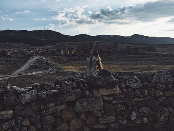 People standing on rock against sky