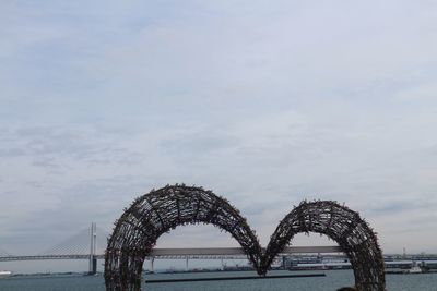 Arch bridge over sea against sky