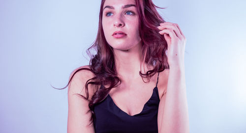 Portrait of beautiful young woman against white background