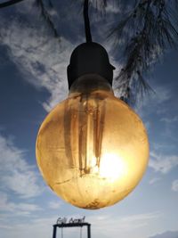 Low angle view of illuminated light bulb against sky