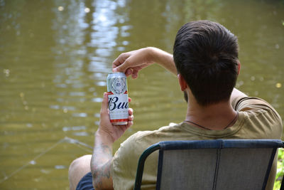 Rear view of man sitting in water