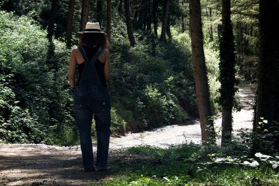 Man standing by trees in forest