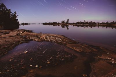 Scenic view of lake against sky at night