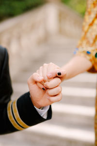 Cropped image of couple holding hands outdoors