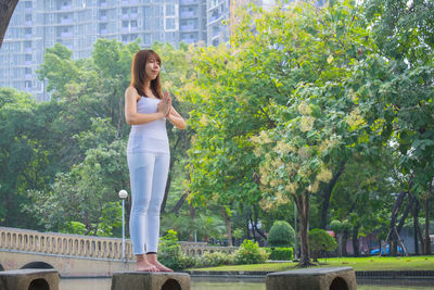 Full length of woman standing against trees
