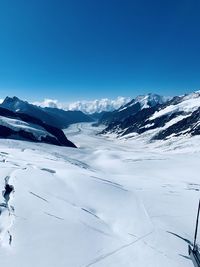 Scenic view of snowcapped mountains against blue sky