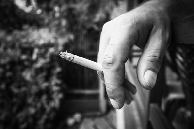 Close-up of hand holding cigarette