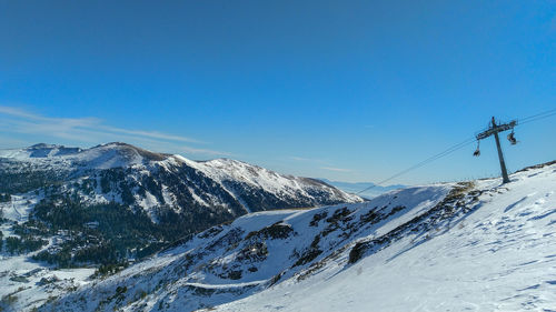 Scenic view of snowcapped mountains against clear blue sky