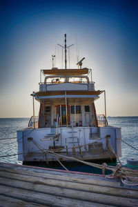 Ship moored on sea against clear sky