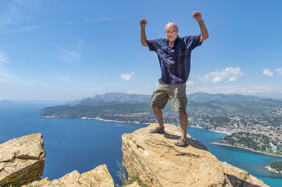 Senior man standing on cliff