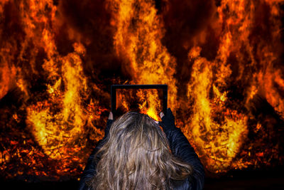 Rear view of a man at bonfire