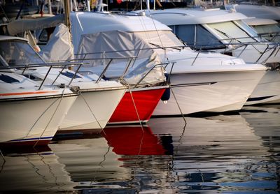 Sailboats moored on harbor against sky