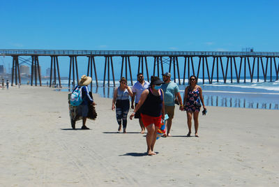 Rear view of people walking on beach