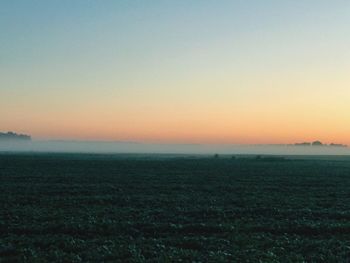 Scenic view of field against clear sky during sunset